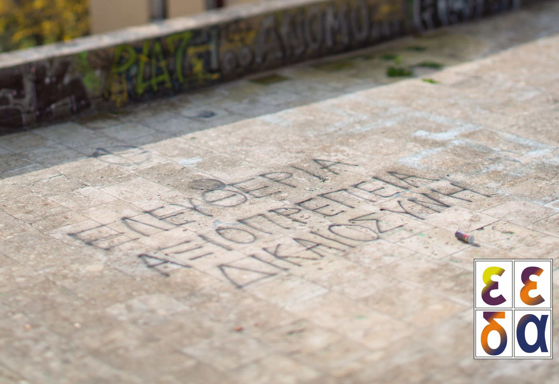 Στιγμιότυπο από το σπότ της ΕΕΔΑ (γραμμένο σε ταράτσα με σπρέυ: Ελευθερία, Αξιοπρέπεια, Δικαιοσύνη)